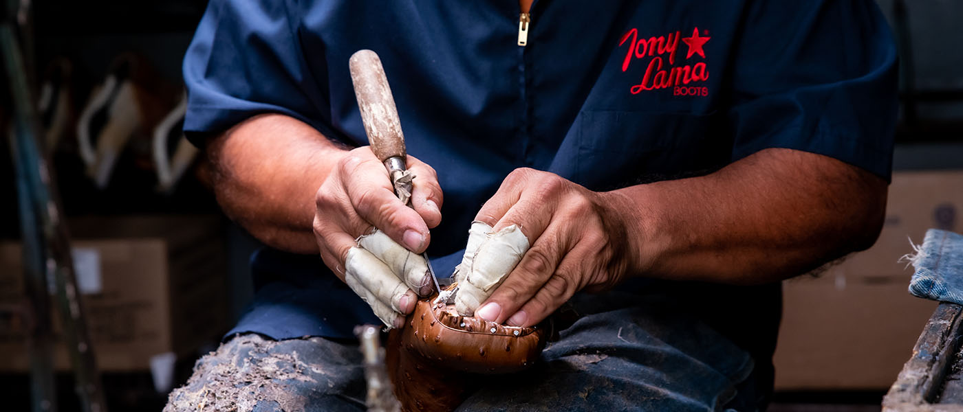 Man works on shoe with tool. 